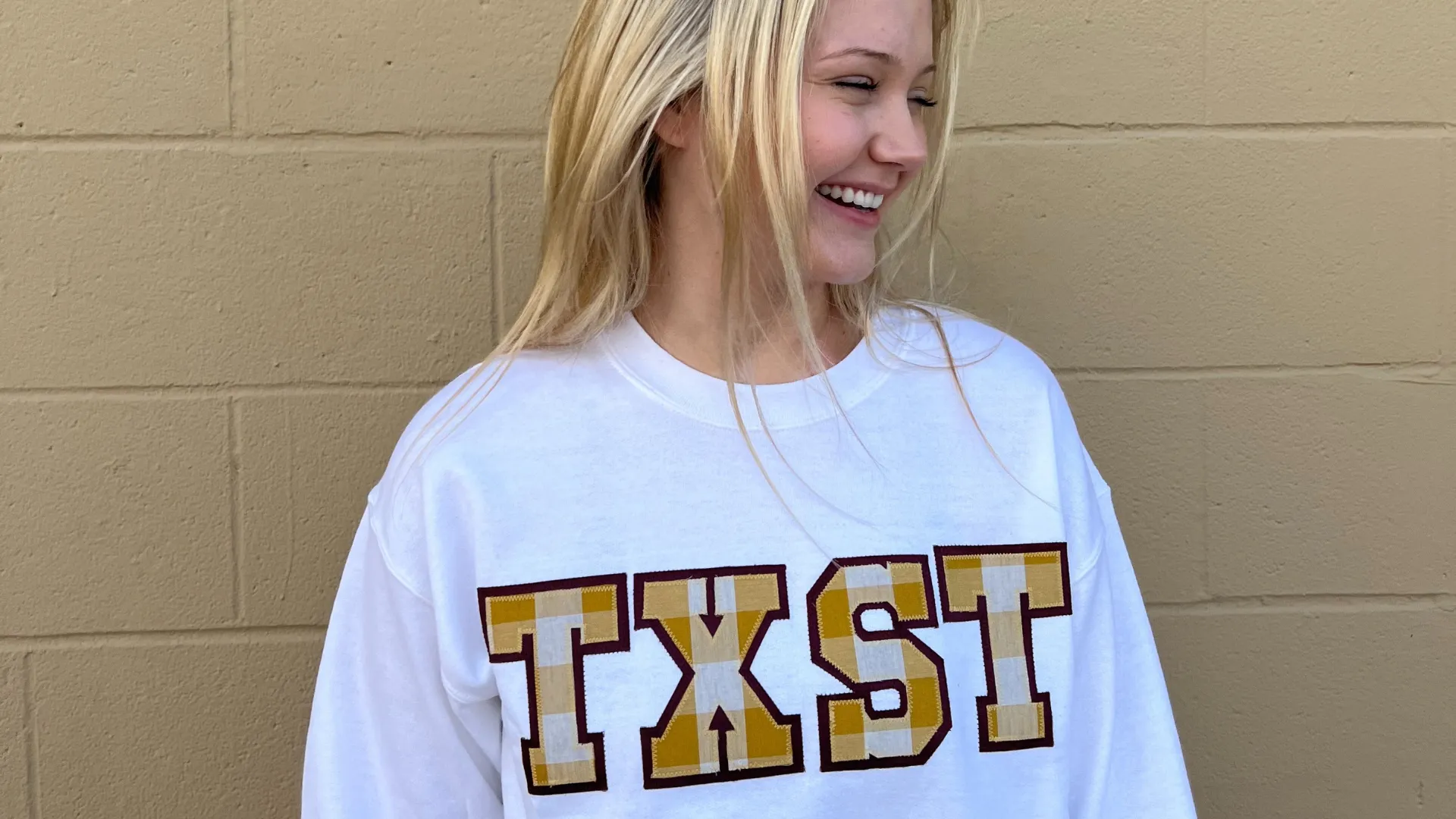 TXST Stitch Letters in Gold/White Gingham with a Maroon background on a White Sweatshirt